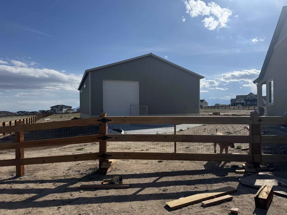 Ranch fence with concrete pad and pole barn